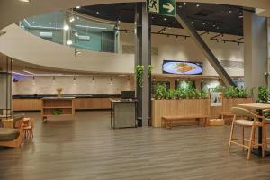 a lobby with a waiting area with potted plants at Ibis Maringa in Maringá