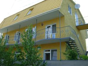 a yellow building with a staircase on the side of it at Мини отель Семейного типа. in Zatoka