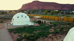 a tent in a field with a mountain in the background at White Camel in Kanab