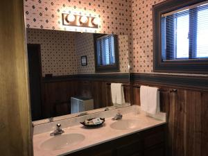 een badkamer met twee wastafels en een spiegel bij Ponderosa Lodge, an Ascend Collection Hotel in Red River +45 foto's