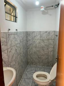 a bathroom with a toilet and a sink at Quarto econômico e confortável in Hortolândia