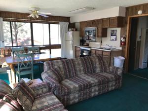 een woonkamer met een bank en een keuken bij Ponderosa Lodge, an Ascend Collection Hotel in Red River