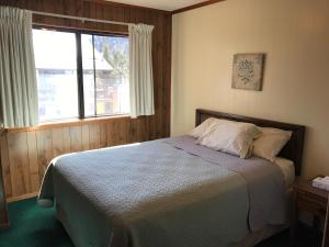 een slaapkamer met een bed en een groot raam bij Ponderosa Lodge, an Ascend Collection Hotel in Red River