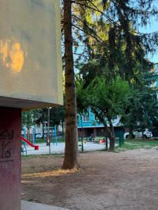 a park with two trees and a playground at Ines Apartment in Sarajevo