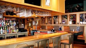a bar with several wine glasses hanging above it at Chieftain Conference Center in Carrington