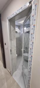 a glass door in a room with a mirror at فندق برج الحوراء ع in Karbala