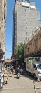 a group of people walking down a street with a building at فندق برج الحوراء ع in Karbala +18 photos