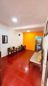 a living room with couches and a yellow wall at Uma Janela Para o Sol in Morro de São Paulo