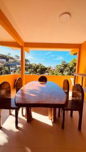 a table and chairs in a room with a large window at Uma Janela Para o Sol in Morro de São Paulo