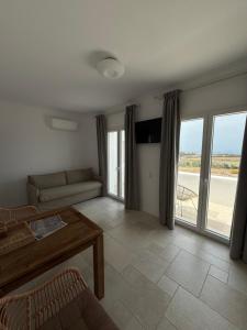 a living room with a couch and a table at Gaia Mykonos Villas & Suites in Tagou