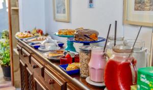 a buffet with many plates of food and drinks at Pousada Café e Prosa Centro Histórico Paraty in Paraty
