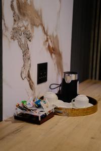 a table with cups and plates and a coffee maker at The ATRIUM BOUTIQUE HOTEL in Polokwane