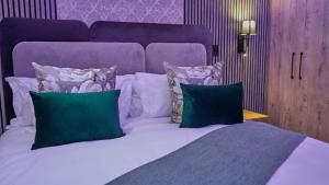 a bedroom with a bed with green and white pillows at The ATRIUM BOUTIQUE HOTEL in Polokwane +9 photos