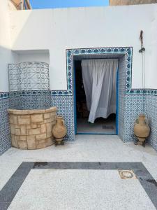 a room with a blue and white wall with a doorway at Dar Sarah in Kelibia