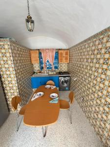 a kitchen with a table and chairs in a room at Dar Sarah in Kelibia