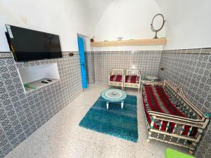 a living room with a tv and a table at Dar Sarah in Kelibia