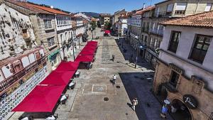 an overhead view of a street with red umbrellas at Casa dos Acevedo in Verín +2 photos