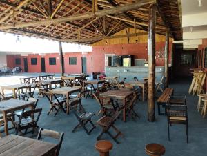 an empty restaurant with wooden tables and chairs at Pousada e Restaurante Jacuba in Arealva