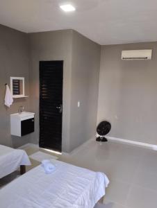 a bedroom with a white bed and a window at Pousada e Restaurante Jacuba in Arealva