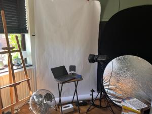 a room with a laptop on a table and a fan at Relax in a Creative Art Space in Guildford