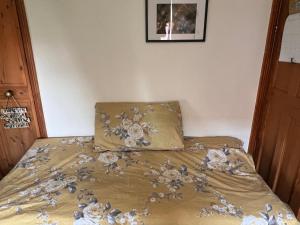 a bed with a comforter with flowers on it at Relax in a Creative Art Space in Guildford