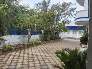 a courtyard of a house with trees and a fence at Adory homes inn in Kelambākkam