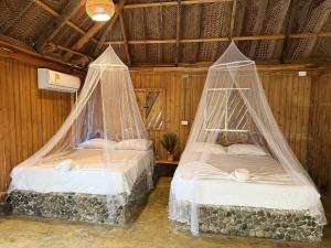 two beds in a room with mosquito nets at Tayrona Cachaco River Ecohostal in El Zaino +142 photos
