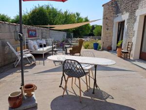 a table and chairs and an umbrella on a patio at la MORINNIERRE in Saint-Jean-de-Beugné