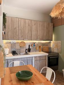 a kitchen with wooden cabinets and a wooden table at Levanda Home in Taktikoúpolis