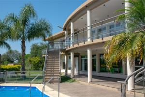 a house with a staircase next to a swimming pool at Altos de Alem in Federación