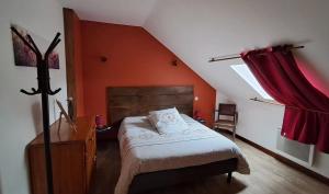 a bedroom with a bed and a red wall at La Maillitardaise - Table d'Hôte in Saint-Pierre-de-Fursac