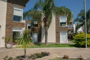 a building with palm trees in front of it at Altos de Alem in Federación