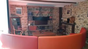 a living room with a red couch and a television at La Maillitardaise - Table d'Hôte in Saint-Pierre-de-Fursac