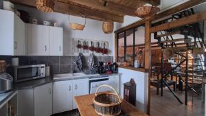 a kitchen with white cabinets and a wooden table at La Maillitardaise - Table d'Hôte in Saint-Pierre-de-Fursac