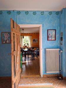 a room with blue walls and a dining room with a table at Frida in Filipstad +5 photos