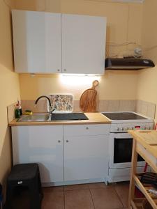 a kitchen with white cabinets and a sink at Seaside olive grove in Pyrgi Thermis +10 photos