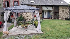 a wooden deck with a gazebo in a yard at La Maillitardaise - Table d'Hôte in Saint-Pierre-de-Fursac