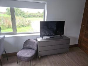 a living room with a chair and a tv at Suaimhneas in Lahinch