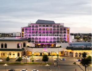 ein großes rosa Gebäude mit Parkplatz in der Unterkunft HS HOTSSON Hotel Leon in León