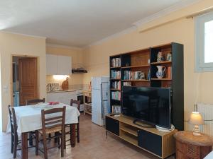 a kitchen and dining room with a table and a television at Seaside olive grove in Pyrgi Thermis