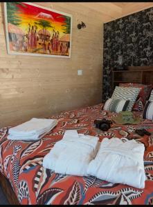 a bed with towels sitting on top of it at Chic and Chill Guest House, gite Safari in Vallon-Pont-dʼArc