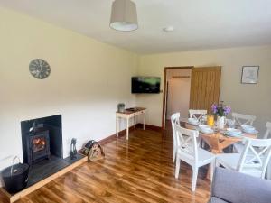a living room with a table and a fireplace at Saddleback Bungalow in Llandrindod Wells