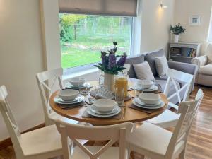 a dining room with a table and chairs and a couch at Saddleback Bungalow in Llandrindod Wells