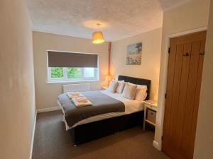 a bedroom with a bed and a window at Saddleback Bungalow in Llandrindod Wells