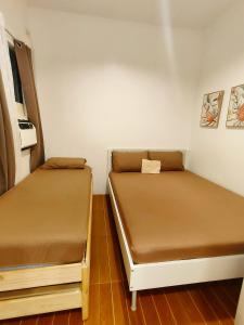 two beds in a small room with brown sheets at Graceland in Lapu Lapu City