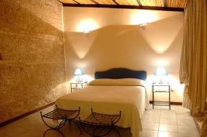 a bedroom with a bed with two tables and two lamps at Il Pero Selvatico in Borgia