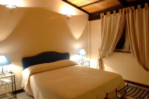 a bedroom with a bed and two lamps and a window at Il Pero Selvatico in Borgia +9 photos