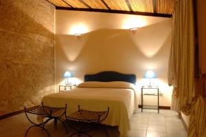 a bedroom with a bed and two lights on two tables at Il Pero Selvatico in Borgia