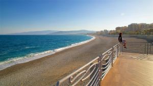 a woman standing on a fence near the beach at Il Pero Selvatico in Borgia