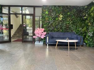 ein blaues Sofa und ein Tisch vor einer grünen Wand in der Unterkunft Hotel Garden in Widin